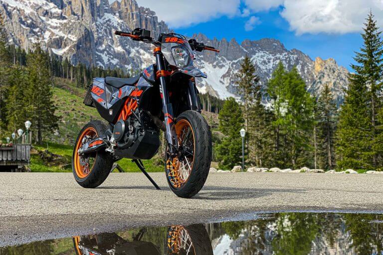 Motorrad mit Nummer 182 und Dekor vor Berglandschaft.