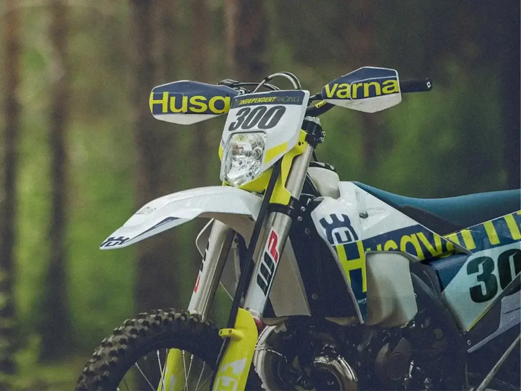 Nahaufnahme eines Husqvarna Enduro-Motorrads mit Custom Dekor mit Waldhintergrund | Independent Racing