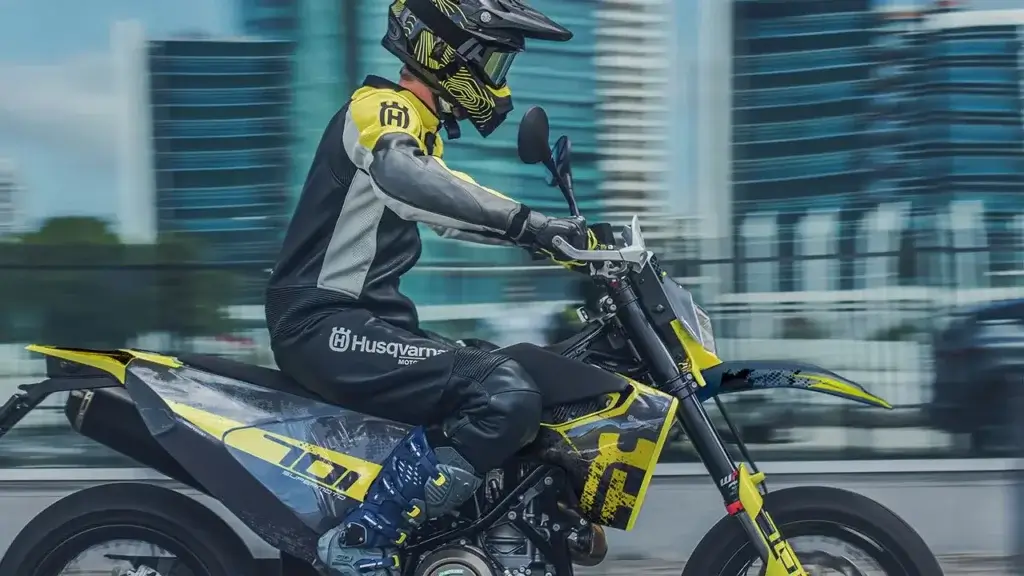 Fahrer auf einer Husqvarna Supermoto mit gelb-schwarzem Dekorkit in urbaner Umgebung | Independent Racing