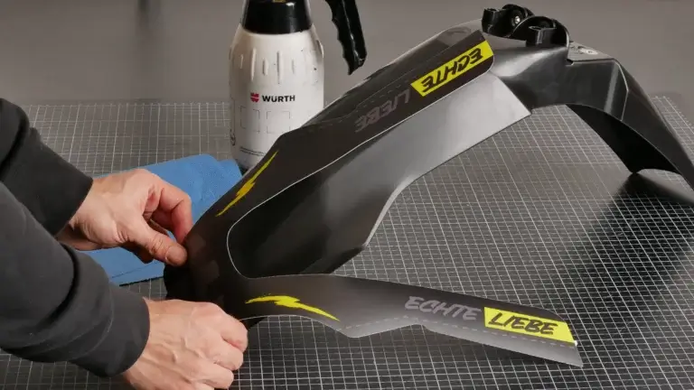 Dekor wird auf einen Kotflügel eines Motorrads geklebt.
