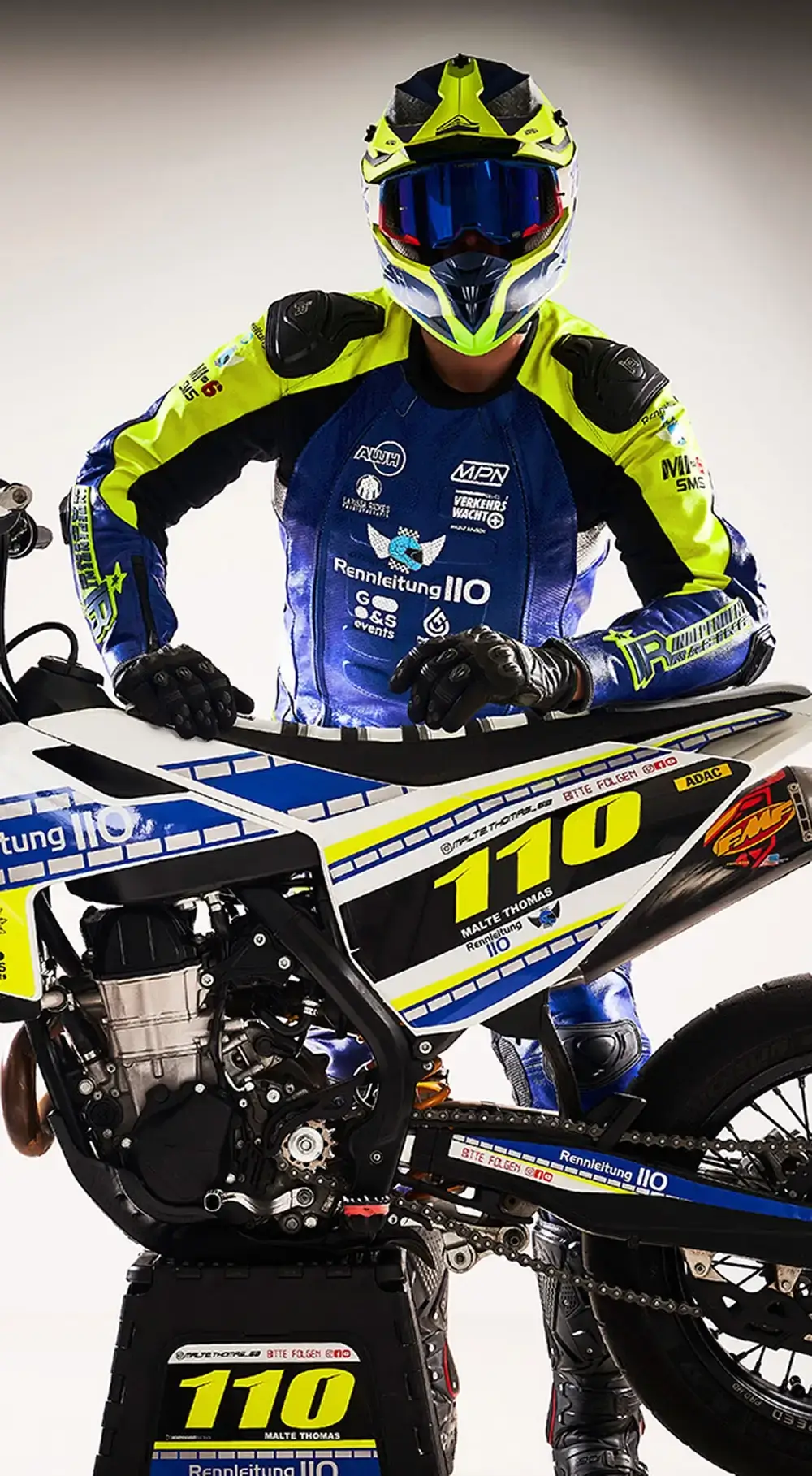 Fahrer in Supermoto-Lederkombi in Polizei-Optik hinter einem Motorrad in Ploizei-Optik.
