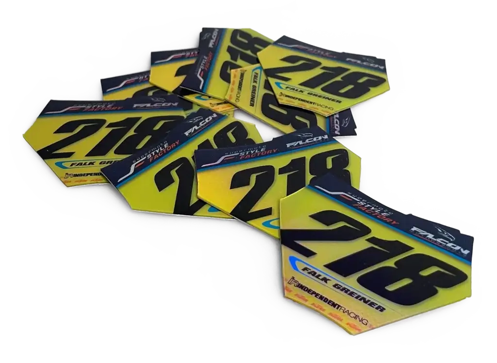Mehrere gelbe Mini-Startnummern mit schwarzer Schrift und Nummer „218“.