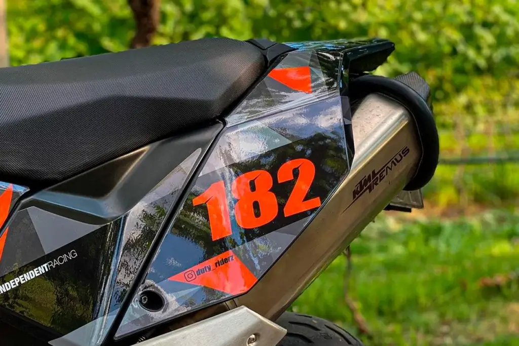 Seitenteil eines Motorrads mit individuellem Dekor mit Nummer 182 und einem Instagram Name.