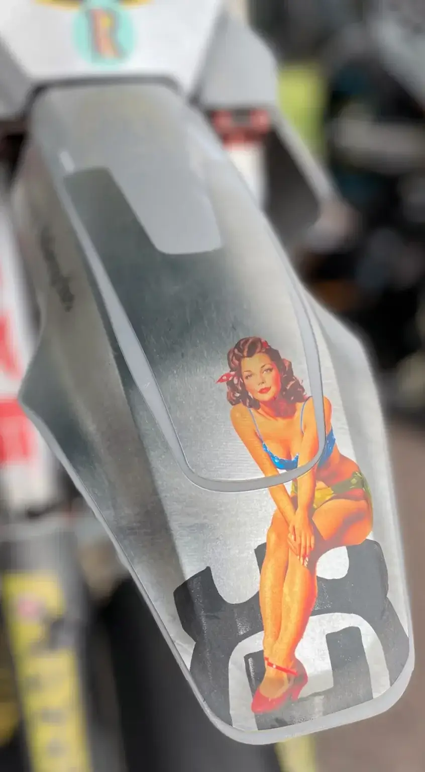 Silver front fender with a pin-up graphic of a woman in swimwear.