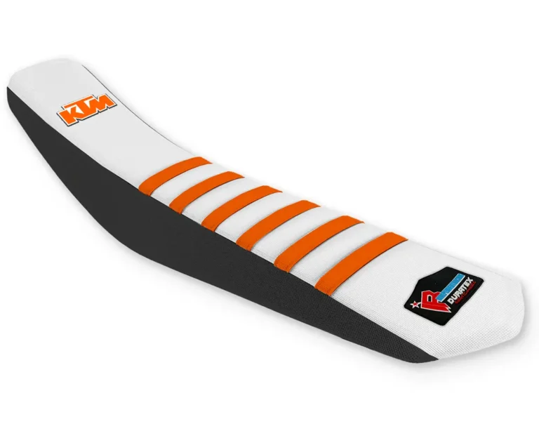 White KTM offroad seat cover with orange ribs, black sides, and KTM logo.