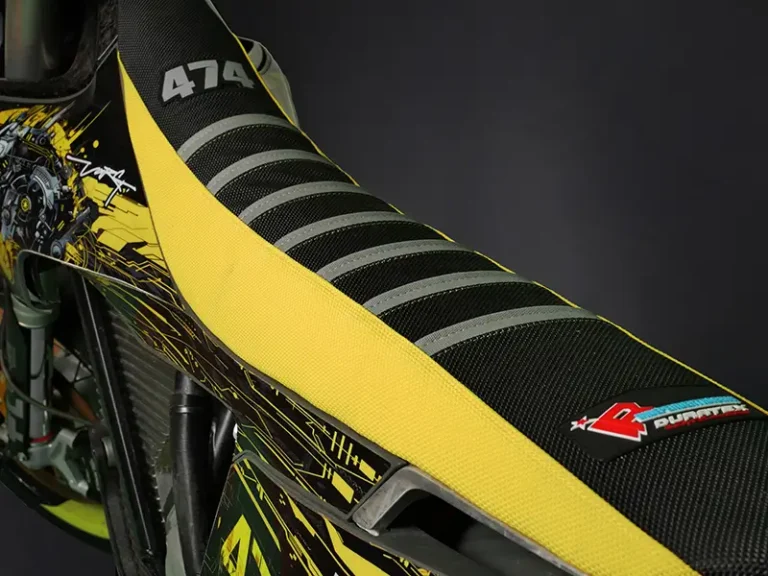 Gelb-schwarzer Sitzbankbezug mit grauen Rippen und Startnummer, montiert auf einer Stark Varg.